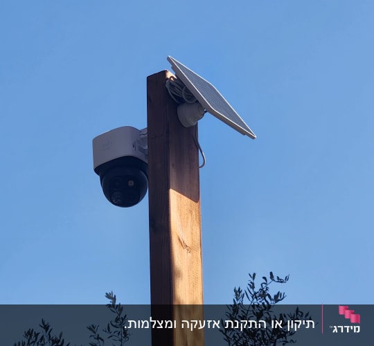 מצלמת אבטחה מותקנת על עמוד עץ עם פאנל סולארי